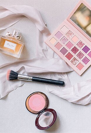 Overhead Shot of Dior Perfume, Charlotte Tilbury Blush, Huda Beauty Makeup and Perfume